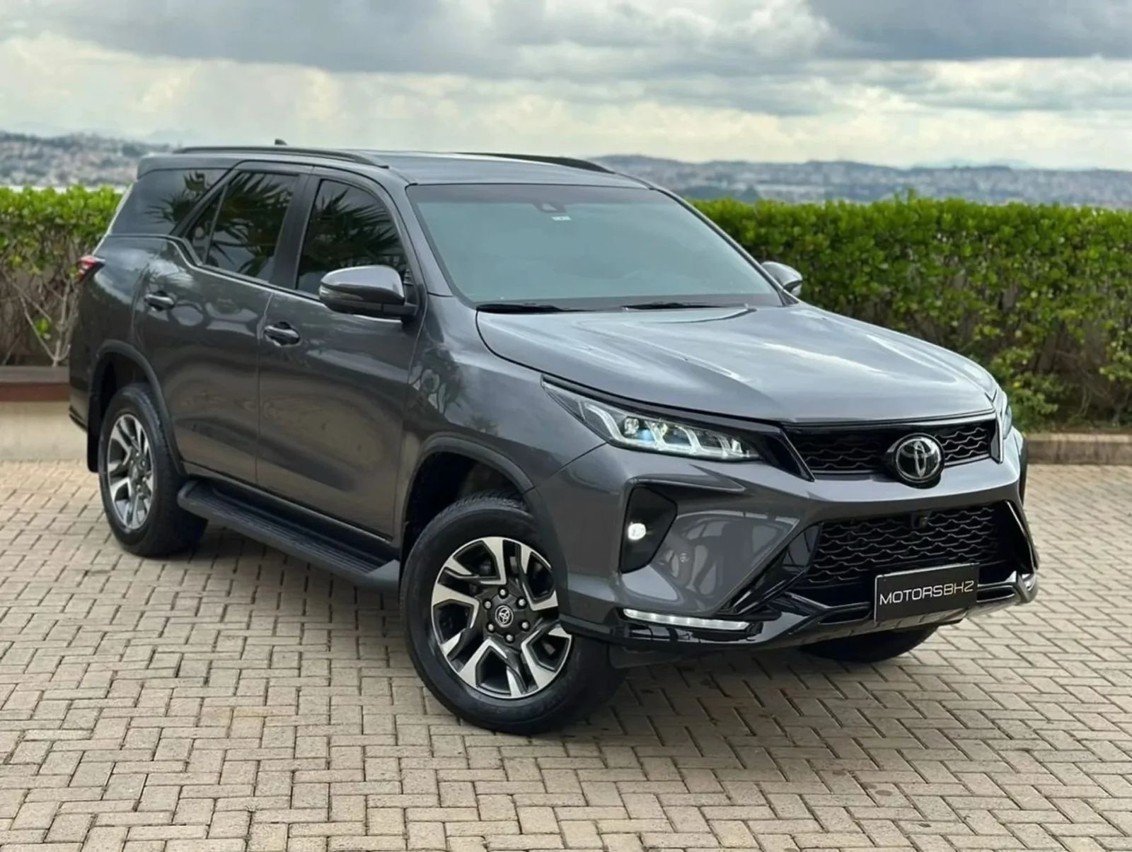 Hilux SW4 cinza de frente estacionada